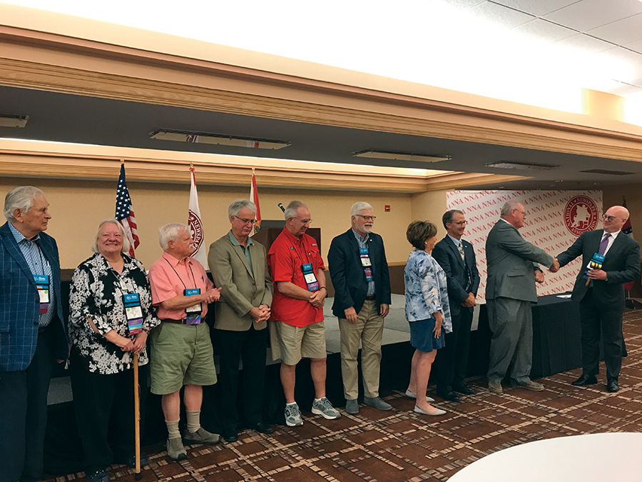 NNA past presidents pass the gavel — L to R: Eugene Johnson, Press Publications, White Bear Lake, Minnesota; Diane Everson, The Edgerton (Wisconsin) Reporter; Steven Haynes, Haynes Publishing, Oberlin, Kansas; Reed Anfinson, Swift County Monitor-News, Benson, Minnesota; Robert M. Williams Jr., NNA director of creative resources, Blackshear, Georgia; Matthew Paxton, The News-Gazette, Lexington, Virginia; Susan Rowell, retired, Lancaster, South Carolina; Andrew Johnson, retired, Horicon, Wisconsin; Matthew Adelman, Douglas (Wyoming) Budget; Brett Wesner, Wesner Publications, Cordell, Oklahoma.