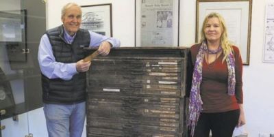 Phelps Anderson (left) and Barbara Beck show off a vintage letterpress type case cabinet, complete with its original shipping tag in Anderson’s hands.