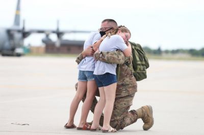 Sgt. First Class Evan Bock hugs his daughters Delaney (left), 9, and Blakely, 7, Saturday July 11, 2020, at the Wyoming Air National Guard in Cheyenne. Evan Bock, a member of  the Wyoming Army National Guard 115th Field Artillery Brigade, was deployed to the Middle East for nearly a year before being sent back to the United States. (Michael Cummo | Wyoming Tribune Eagle)